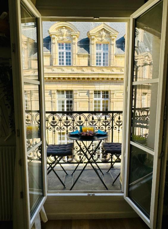 Elle offre une vue sur un balcon avec une table et un bâtiment. dans l'établissement Cosy Studio with balcony Paris Center - Sorbonne - Pantheon - Notre-Dame, à Paris