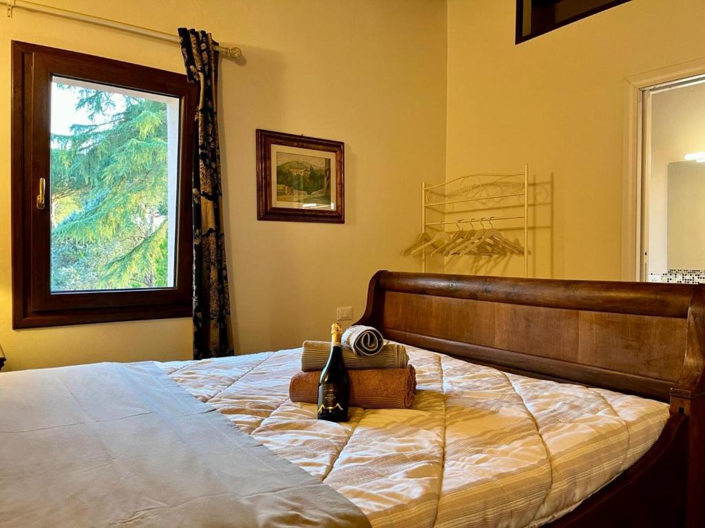 Schlafzimmer mit einem Bett und einem Fenster in der Unterkunft Casale Collecchio Siena in Siena