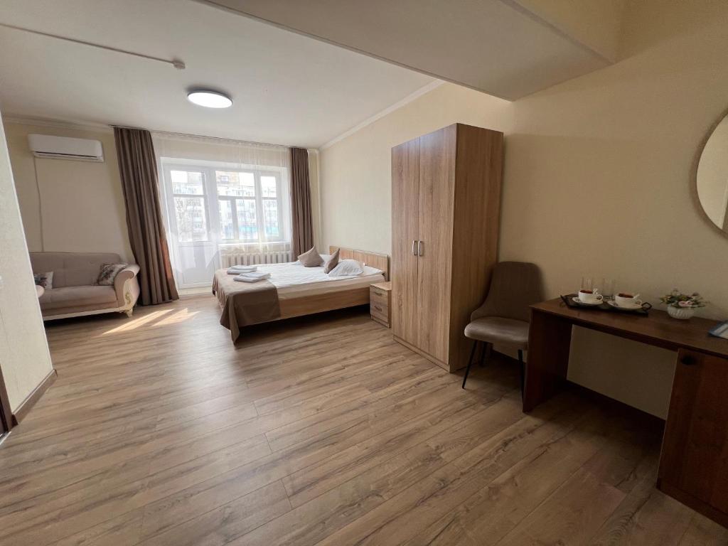 a room with a bed and a desk in a room at Belon inn in Astana