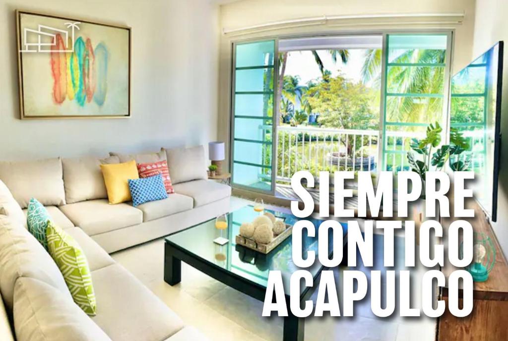 a living room with a couch and a table at Vista al Lago con balcón en Mayan Lakes in Acapulco