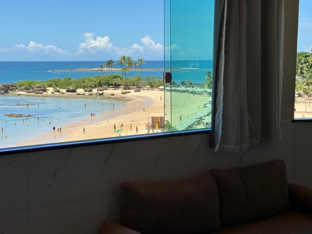 uma vista para a praia a partir de uma janela em Home Superior Nascer do Sol em Cairu