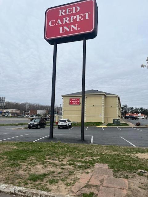 a red car expert inn sign in a parking lot at Red Carpet Inn Quantico in Dumfries