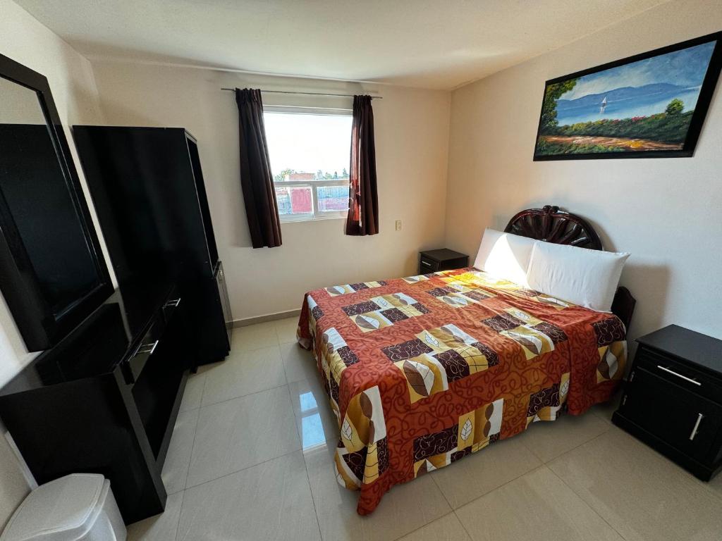 a bedroom with a bed and a television in it at PEDRERA 39 in San Felipe Hueyotlipan