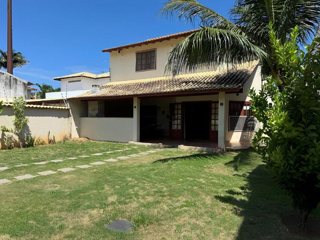 une maison avec un palmier en face dans l'établissement Casa encantadora a 100 m da praia de Geribá - WIFI 200MB - TV Smart - 5 Quartos - Garagem - Cozinha equipada - Churrasqueira, à Búzios