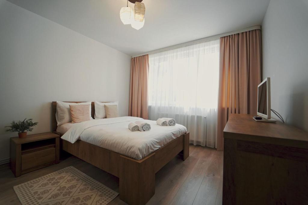 Luxury Apartament Ultracentral of Suceava Esplanada في سوسيفا: غرفة نوم بسرير ومكتب وتلفزيون
