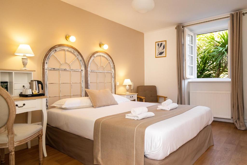 ディナンにあるDemeures & Châteaux - Hôtel De La Porte Saint-Maloのベッドルーム1室(ベッド1台、タオル2枚付)