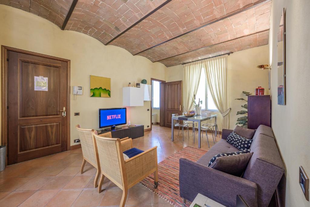 sala de estar con sofá y TV en Modena Palace Suite [Duomo - 5 Stelle], en Módena