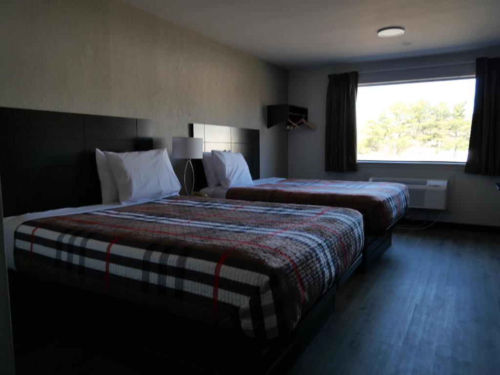 Habitación de hotel con 2 camas y ventana en Hilltop Express Inn, en Groton