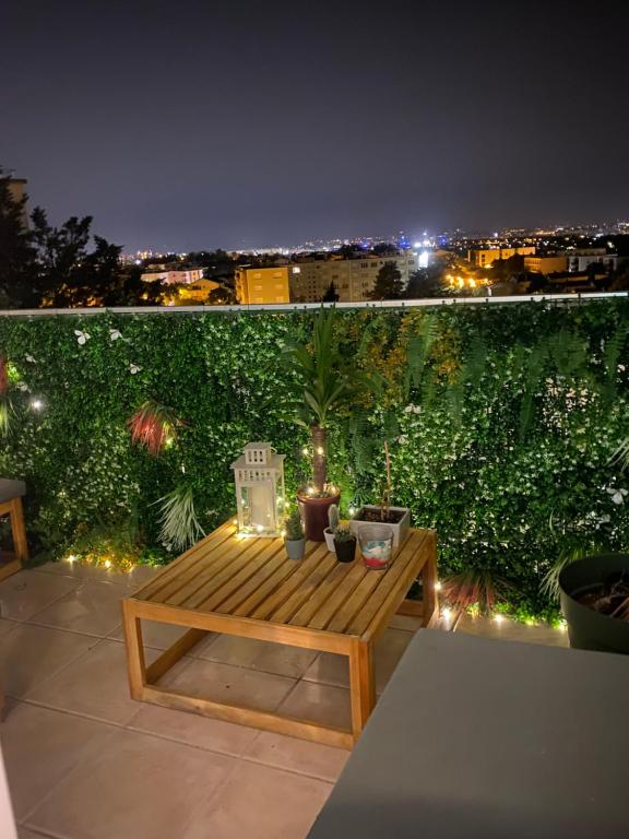 a wooden bench sitting on top of a balcony at night at Le paisible in Décines-Charpieu