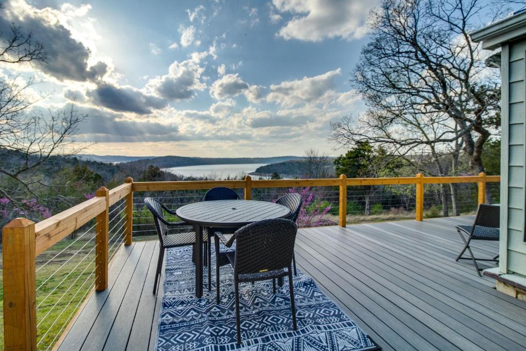 une terrasse en bois avec une table et des chaises. dans l'établissement Henderson Cabin with Deck and Scenic Lake Views!, à Henderson