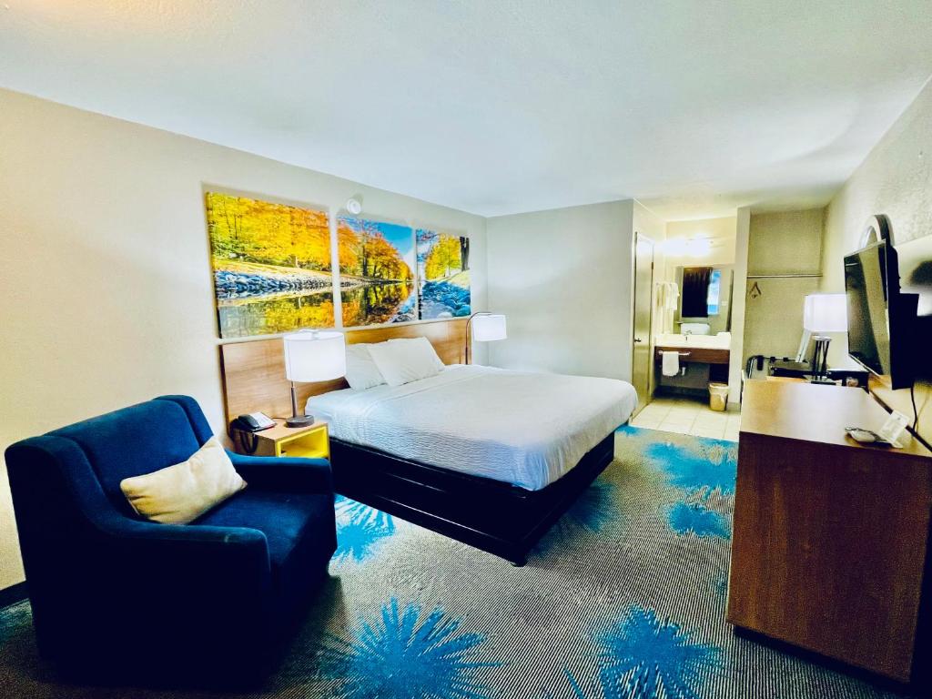 a hotel room with a bed and a chair at Days Inn by Wyndham Ardmore in Ardmore