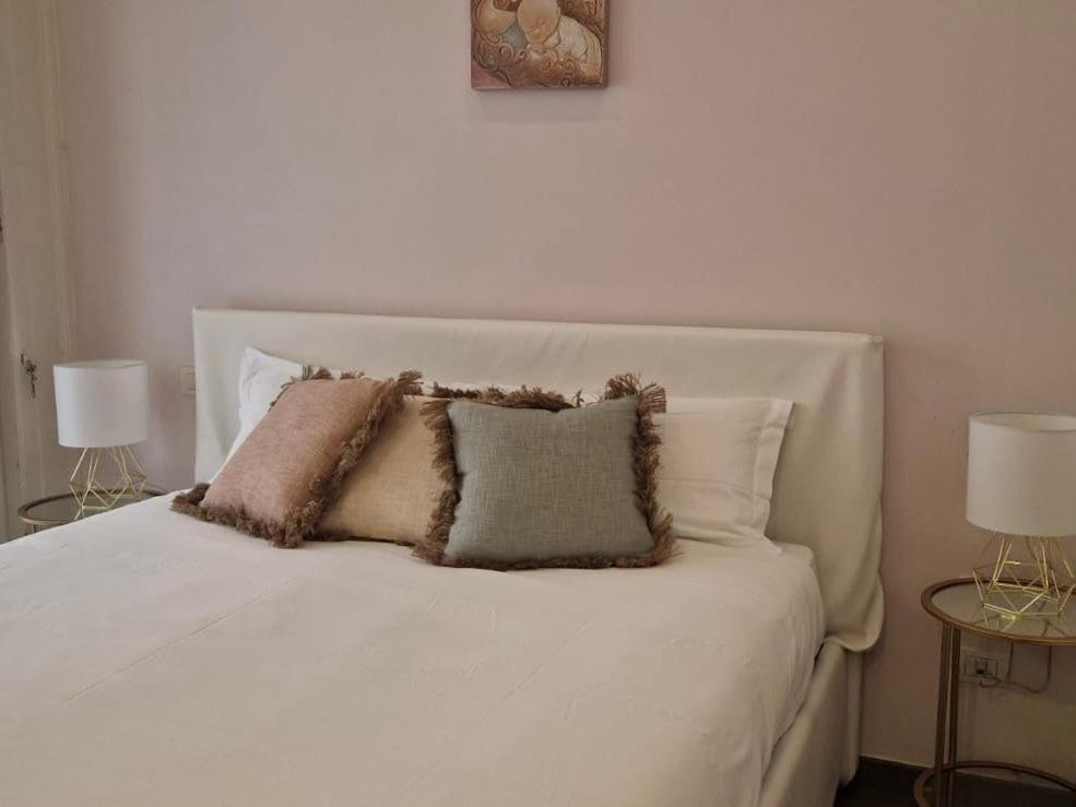 un letto bianco con tre cuscini sopra di Maison Michela Sorrento a Sorrento