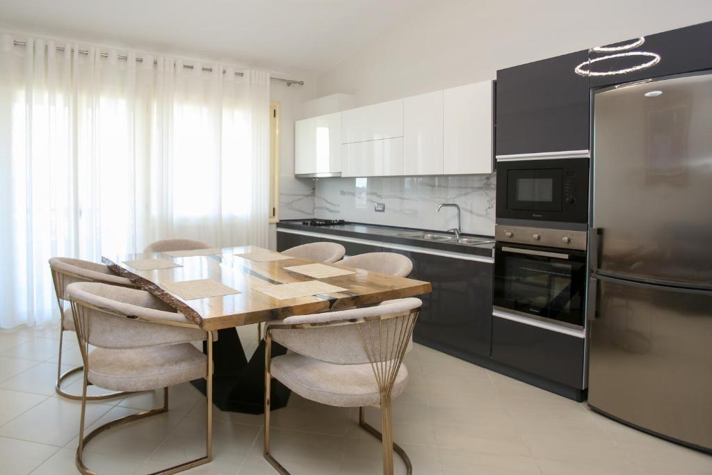 a kitchen with a wooden table and some appliances at Sale e Sole Rooms in Vlorë