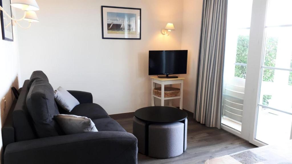 un salon avec un canapé et une télévision dans l'établissement Port du Crouesty Cap'Océan - maeva Home - 2 Pièces 4 Personnes - Confort - vue sur le Port MAE-1315, à Arzon