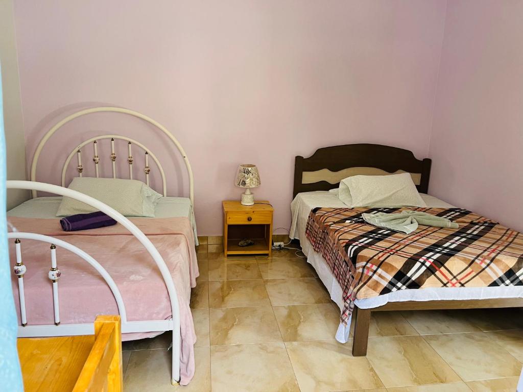 a bedroom with two beds and a night stand with a lamp at Casa Adriano & Filomena in Portela