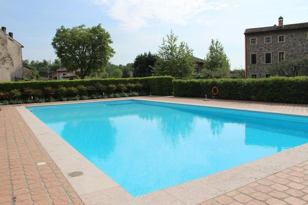 een groot blauw zwembad in een tuin bij Casa Borghetto 8 Lago di Garda in Valeggio sul Mincio