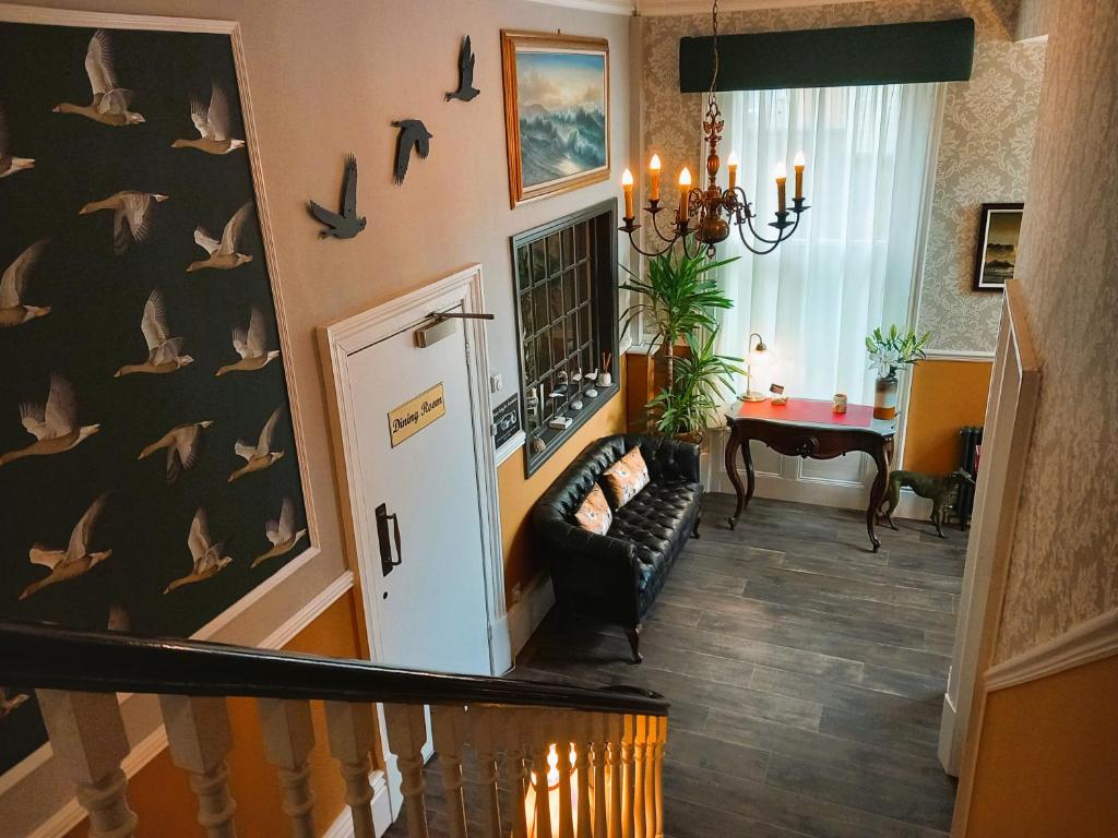 a hallway with a staircase with birds on the wall at Ashburton House - B&B in Scarborough