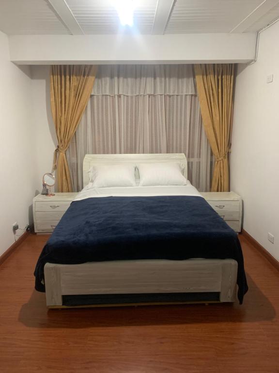 sypialnia z dużym łóżkiem i niebieskim kocem w obiekcie CONFORTABLE APARTAMENTO w mieście Bogota