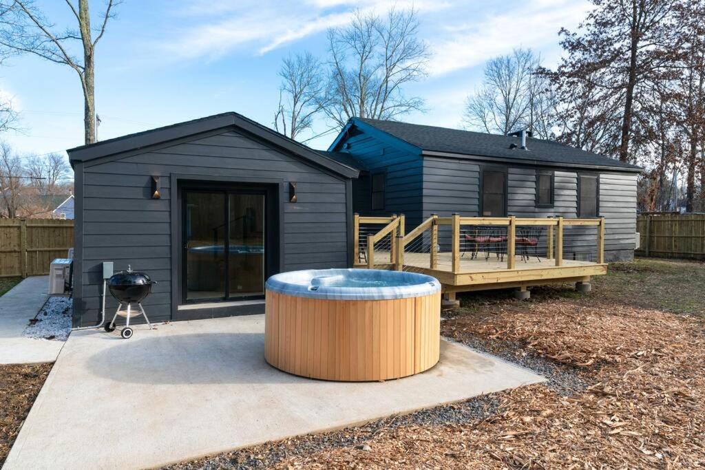 una pequeña casa negra con un barril en el patio en New Paltz Zen Wellness Cabin w/ Hot Tub, en New Paltz