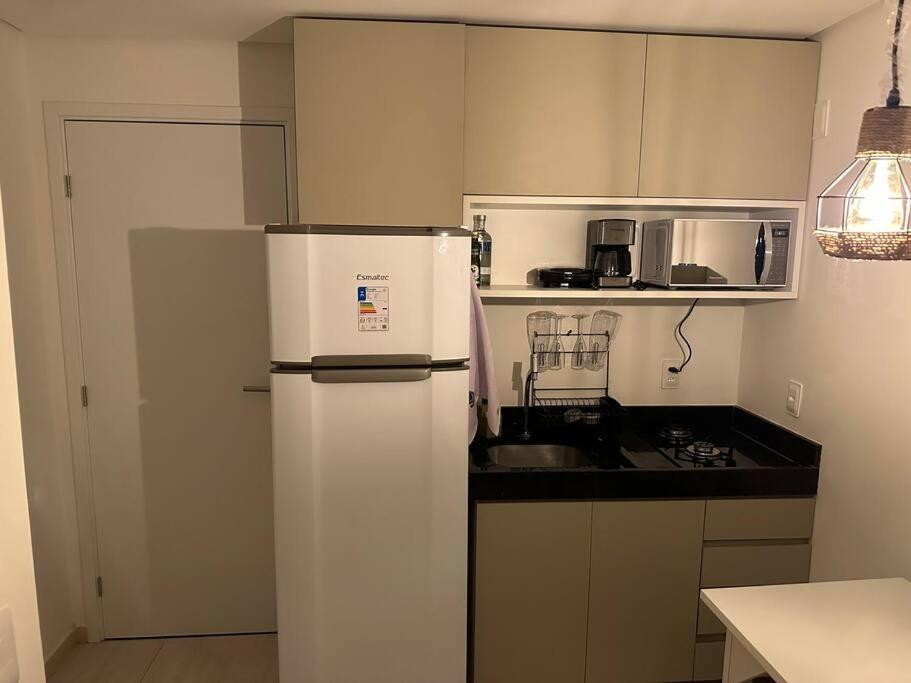 Flat Beira Mar Porto de Galinhas - Pé na areia في بورتو دي غالينهاس: مطبخ مع ثلاجة بيضاء ومغسلة