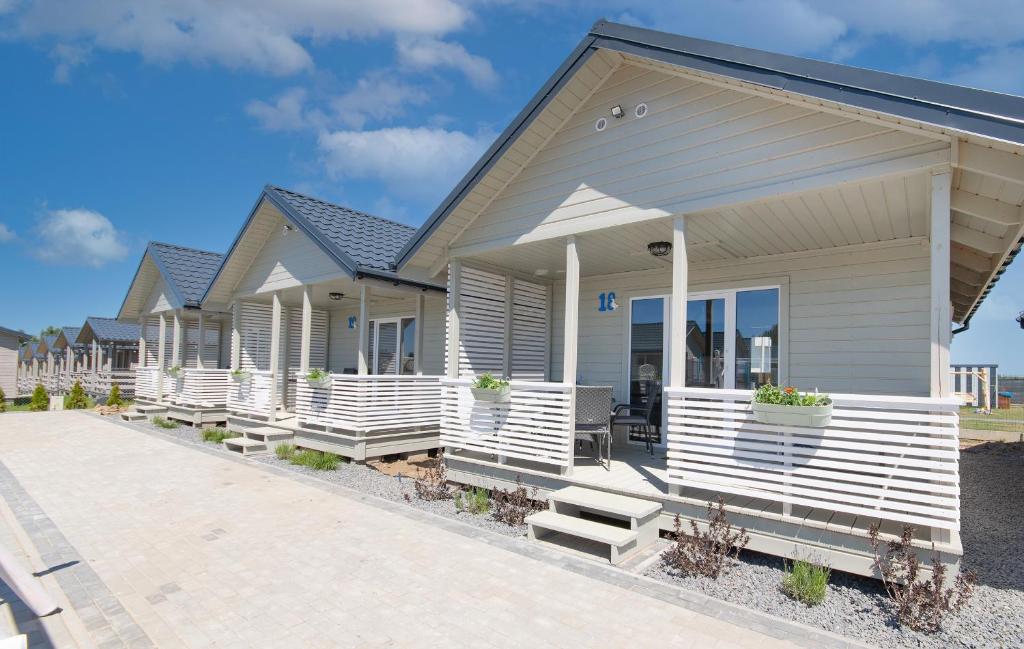 a row of modular homes with white risers at Morska Gąska- domki letniskowe in Mielenko