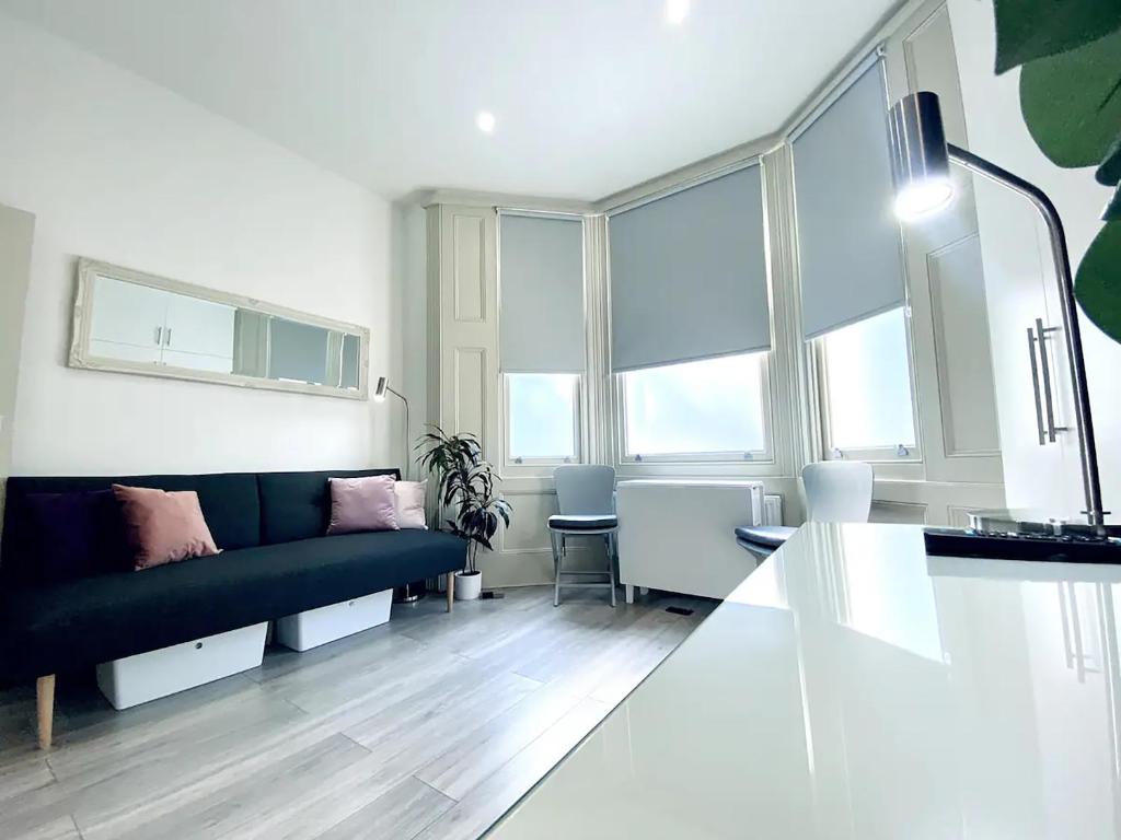 ブライトン＆ホーブにあるApt 04 Seaside Serenity Chic Studio Steps to Promenadeのソファとテーブルのあるリビングルーム