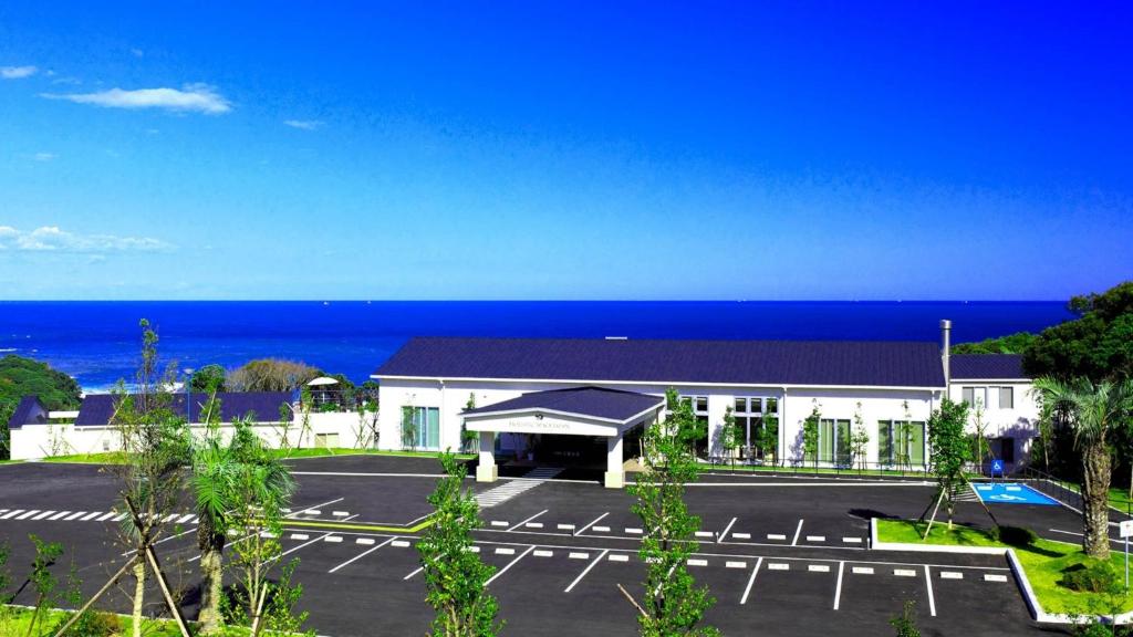 HOTEL HOLISTIC RESORT - Vacation STAY 34557v في Taiji: مبنى مع موقف للسيارات أمام المحيط