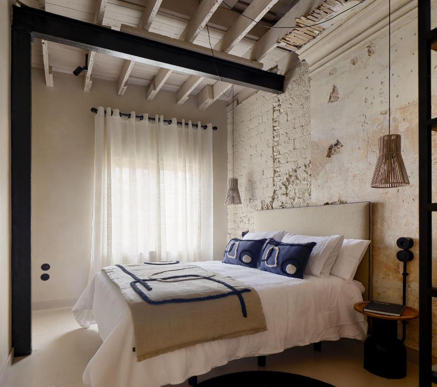 um quarto com uma cama grande e almofadas azuis em APARTAMENTO DISEÑo GALIANA 6 ARENA AVILÉS ASTURIAS em Avilés