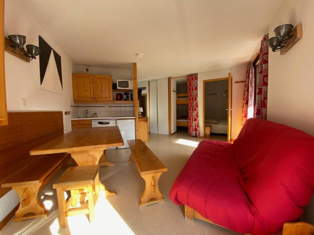 a living room with a red couch and a table at Appartement Morillon 1100, 2 pièces, 6 personnes - FR-1-642-62 in Morillon