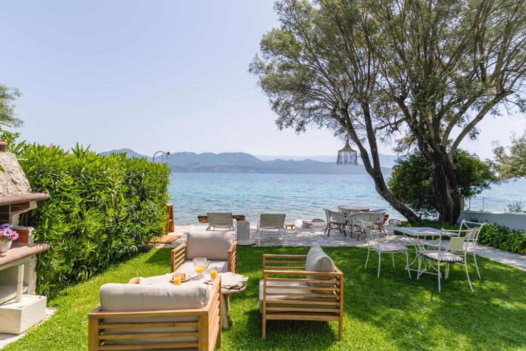 a backyard with a table and chairs and the water at Agnadi Suites in Nikiana