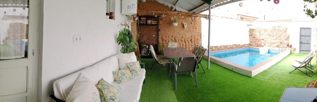 Casa Rural Abuela Maxi في Ríolobos: غرفة مع مسبح وطاولة وكراسي