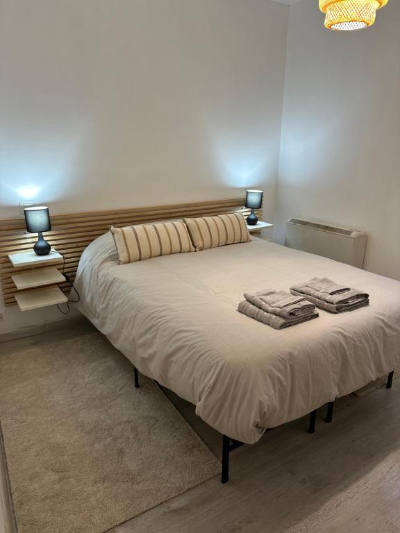 a bedroom with a bed with two lamps on it at A 5 min del aeropuerto + IFEMA in Madrid