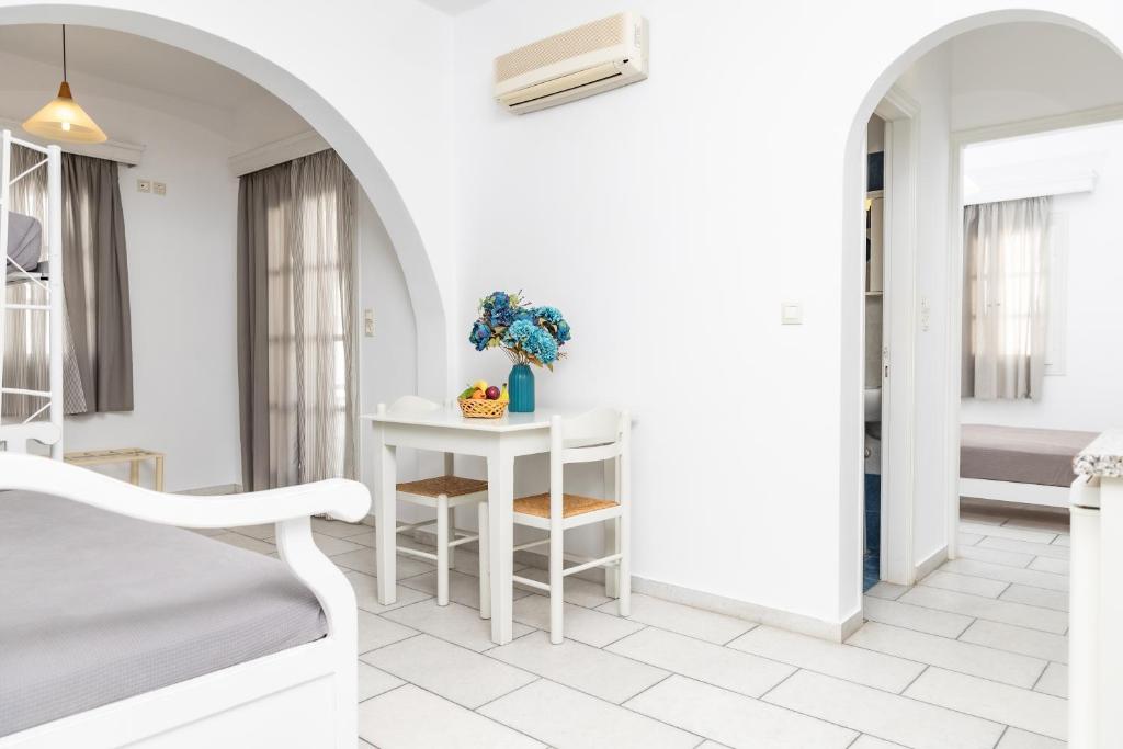 a white room with a table and a bed at Depis studios & apartments in Naxos Chora