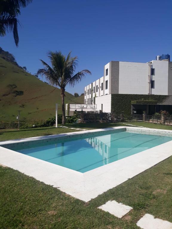 a swimming pool in front of a building at Hotel Fazenda Valaisan in Santa Maria Madalena