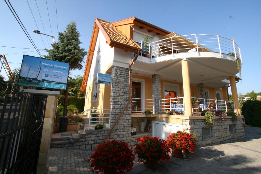 une maison avec une terrasse couverte ronde et un balcon dans l'établissement Apartman Vitorlás Vendégház, à Balatonfüred