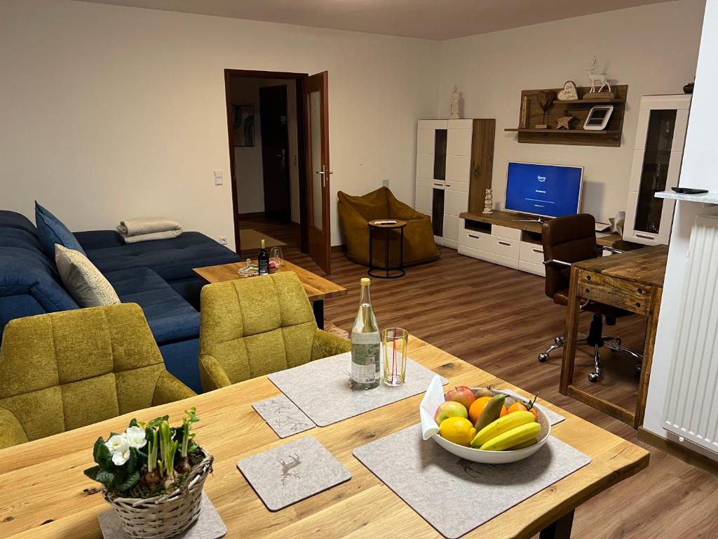 ein Wohnzimmer mit einem Tisch und einer Obstschale darauf in der Unterkunft Appartement Schwetzingerstadt in Mannheim
