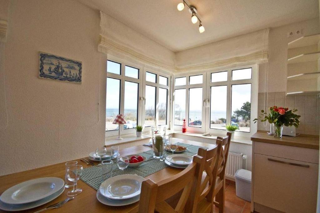 a dining room with a table and some windows at Haus-Weite-Sicht in Wittdün