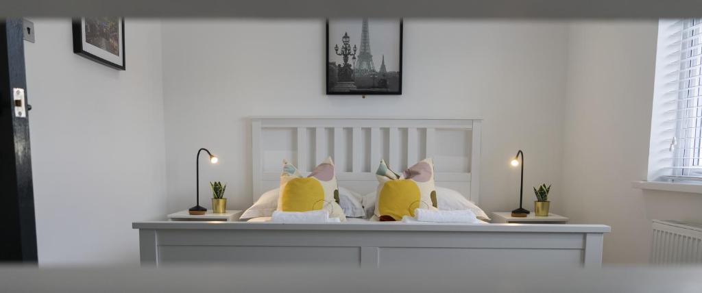 a bedroom with a bed with yellow pillows at Hope Apartments Belfast - Tullymore in Belfast