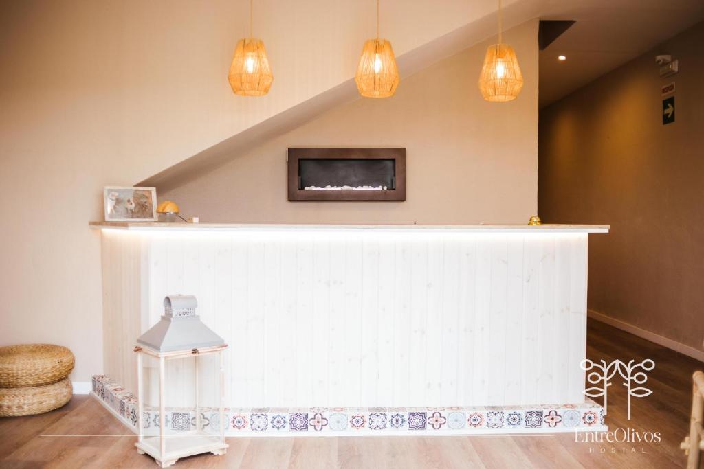 a living room with a white wall with a fireplace at HOSTAL ENTREOLIVOS in Badajoz