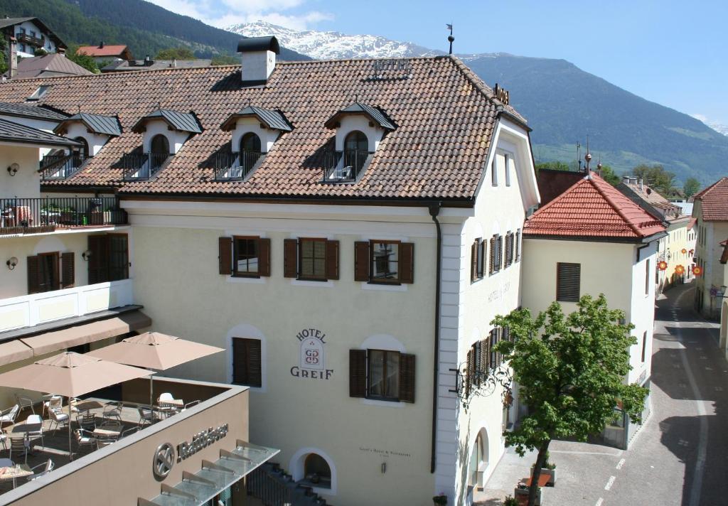 einen Blick auf ein Gebäude mit einem Berg im Hintergrund in der Unterkunft Hotel Greif in Mals im Vinschgau