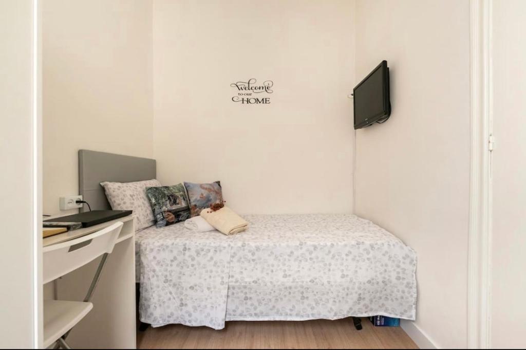 a small bedroom with a bed and a tv at Quiet Love Suites in Barcelona