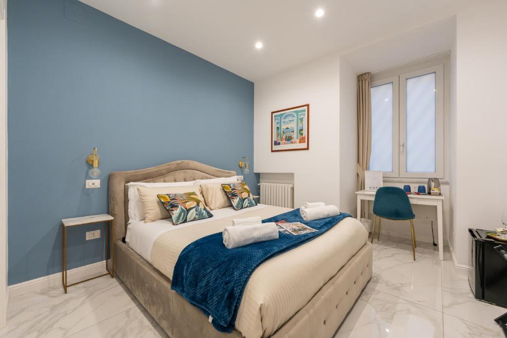 una camera con un grande letto con una parete blu di Maison Morghen a Napoli