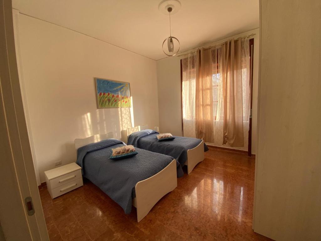 sypialnia z 2 łóżkami i oknem w obiekcie Nuova Luna w mieście Salerno