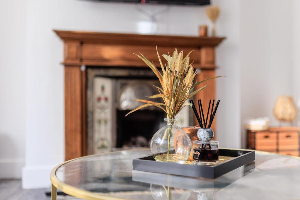 Una mesa de cristal con un jarrón con hierba dentro. en Stockton Lodge, en Hartlepool