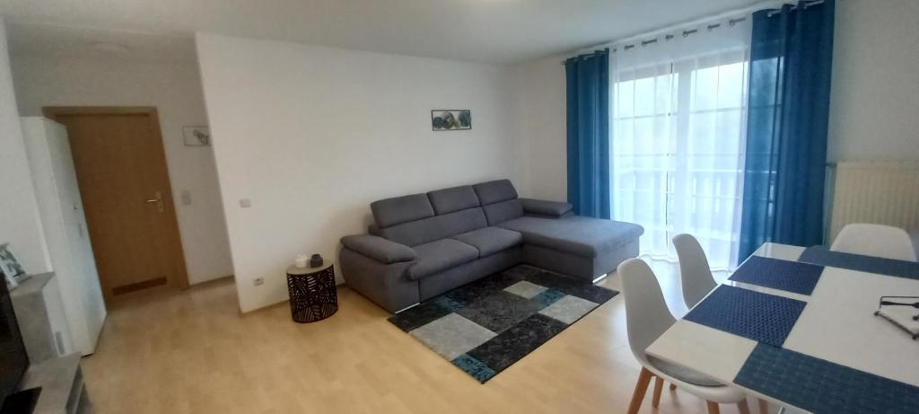 a living room with a couch and a table at Moderne Ferienwohnung in Schwandorf in Schwandorf in Bayern