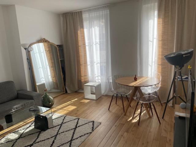 un salon avec un canapé et une table dans l'établissement Cosi Appartement, à Clichy