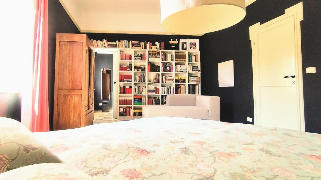 1 dormitorio con 1 cama y estantería con libros en Matilde Rooms en La Spezia