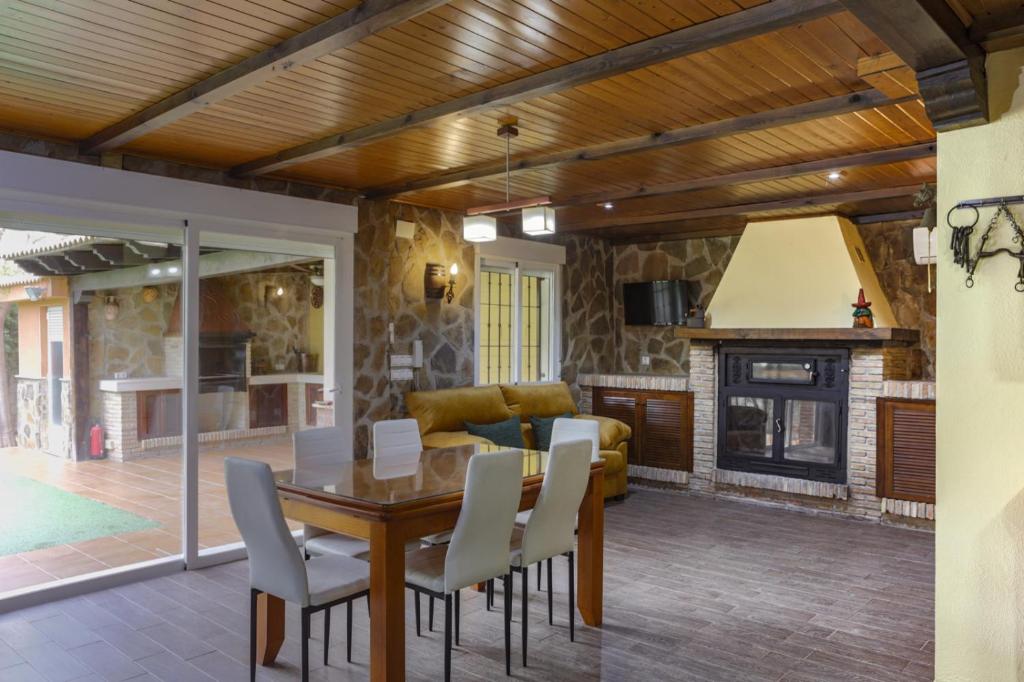 a living room with a table and a fireplace at Villa Rural Las Lomas in Jaén