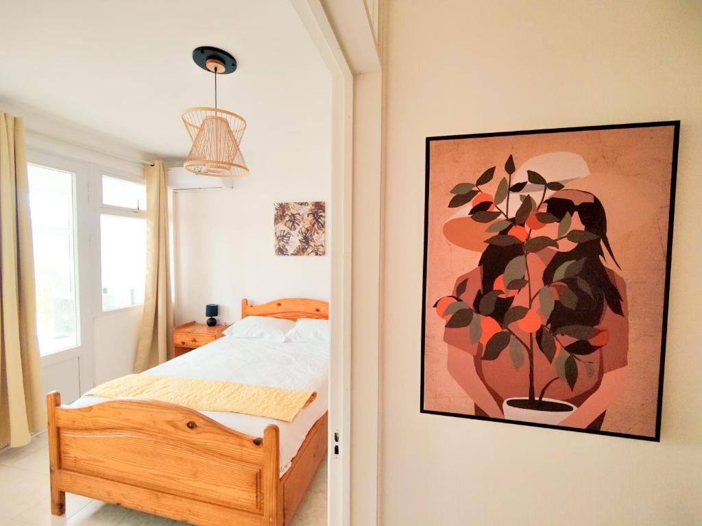 a bedroom with a bed and a painting on the wall at Fibonacci Beachfront Apartment in Flic-en-Flac