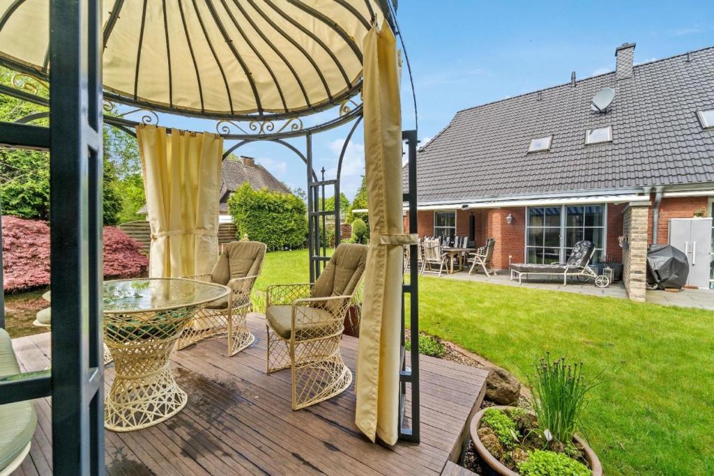 een tuinhuisje met stoelen en een tafel op een patio bij Ferienwohnung in Ottersberg mit Eigener Terrasse in Ottersberg